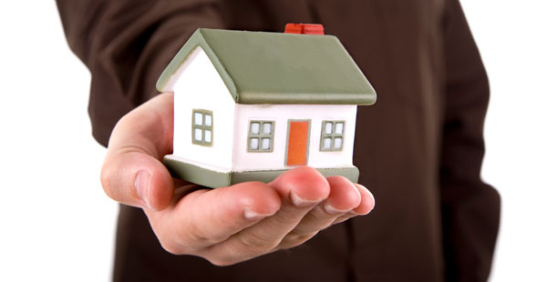 photo illustration of a man holding small model of a house, representing a propfessional's care