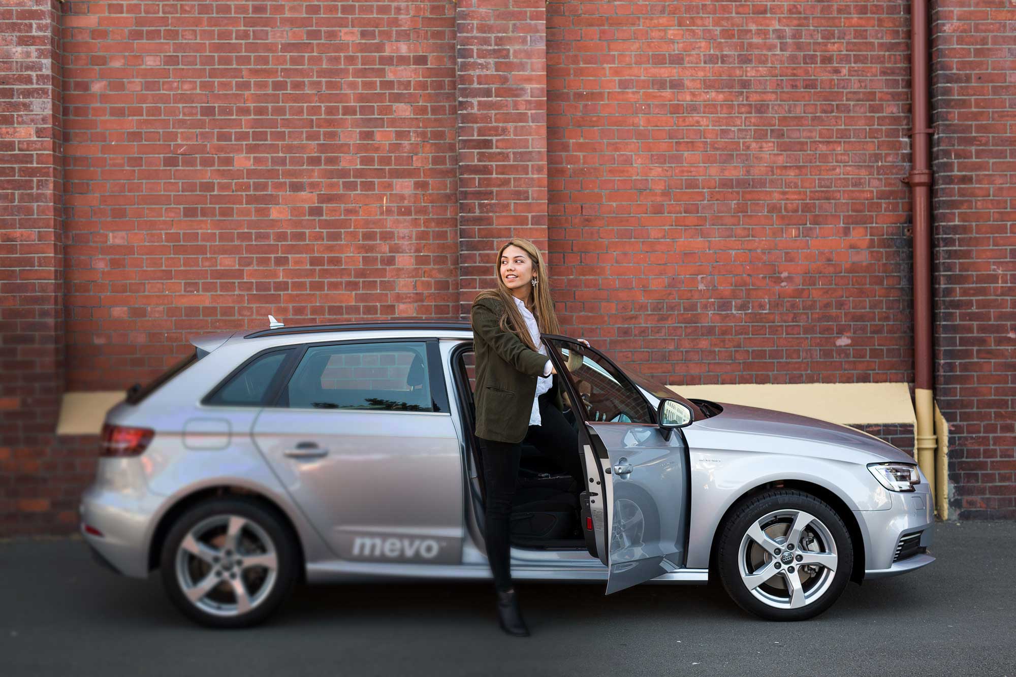 Woman getting out of Audi A3 e-tron in the city
