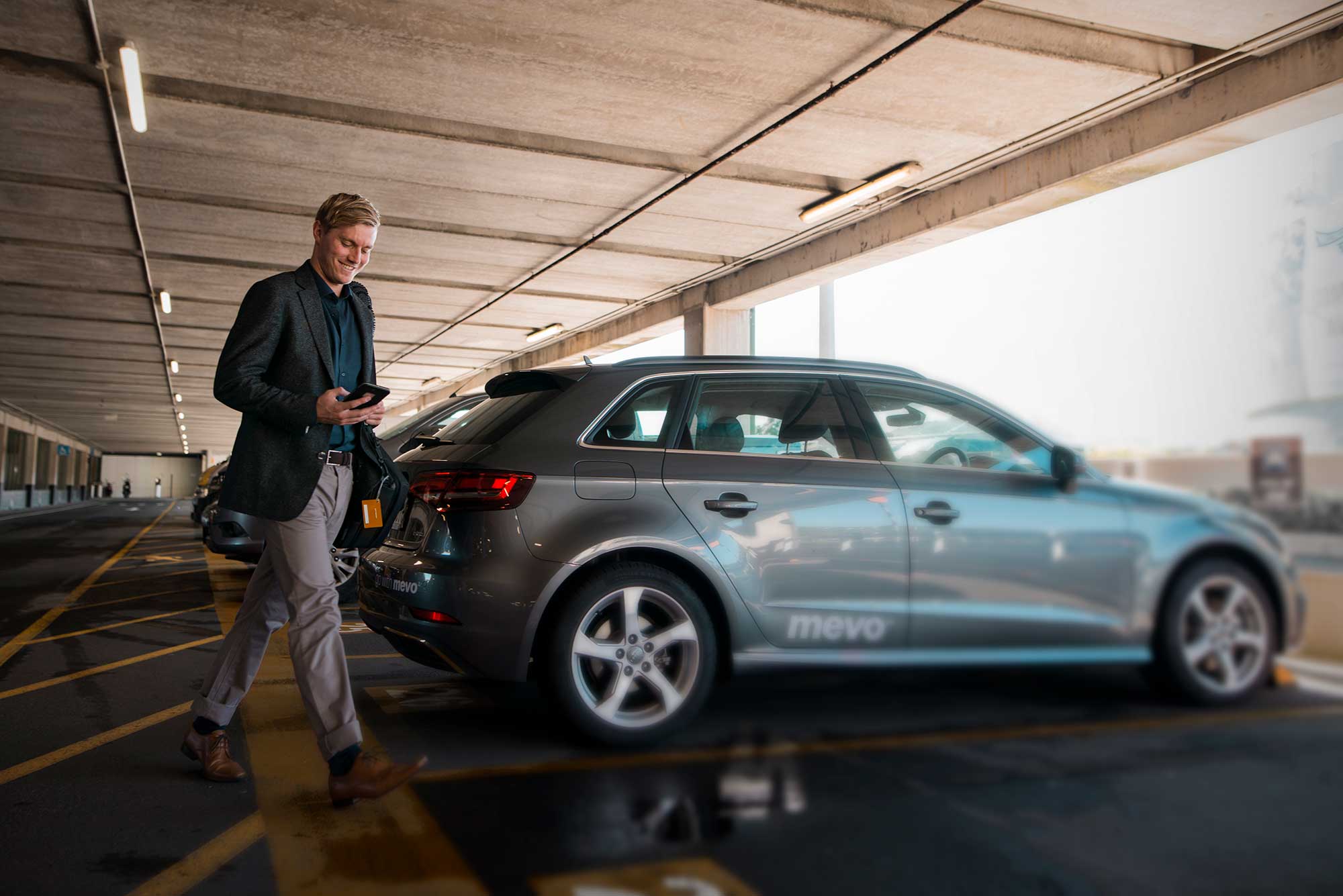 Man opening Audi A3 e-tron with his smartphone at Wellington Airport