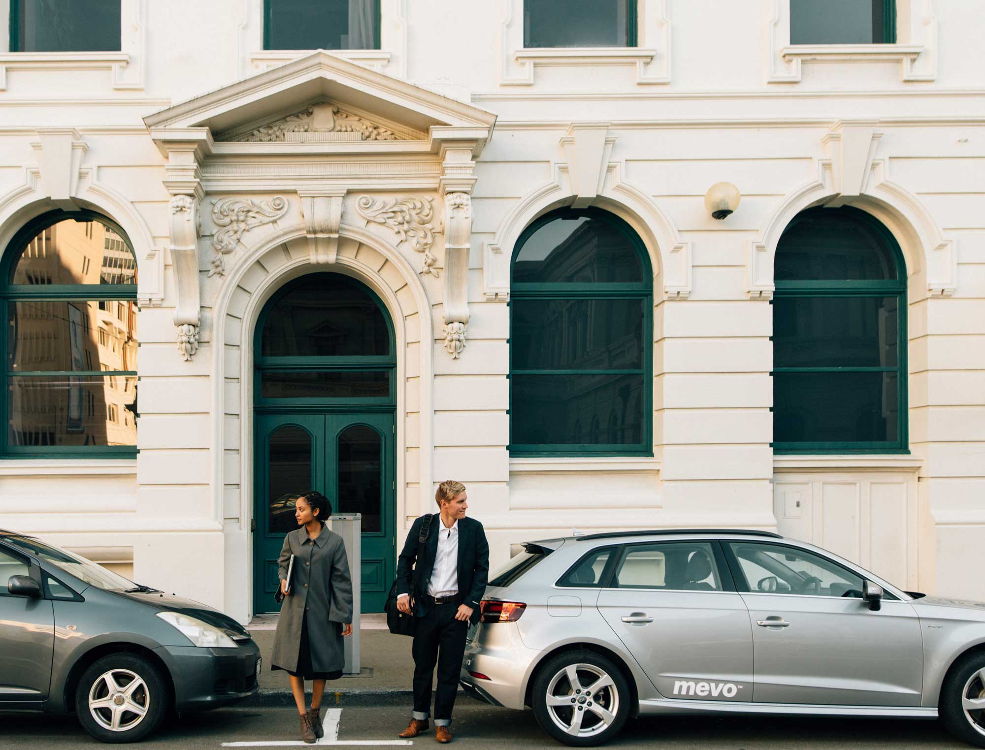 Man and woman next to Mevo Audi A3 e-tron on a city street